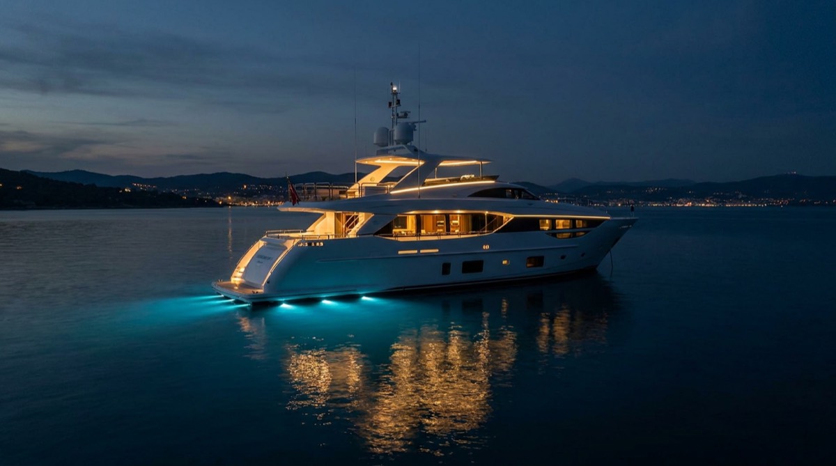 Superyacht at anchor at dusk with exterior and underwater lighting